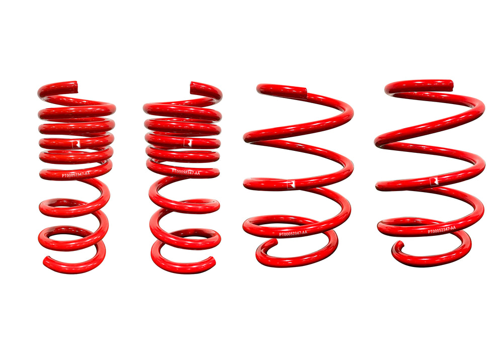 Four red coil springs of varying heights and coils, arranged side by side against a white background, evoke the precision of Roush Mustang Lowering Springs. Their design hints at optimized spring rates and promises an aggressive drop for the discerning car enthusiast.