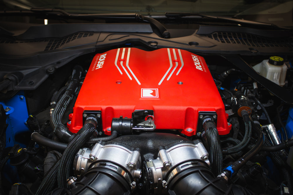 Close-up of a car engine with a striking red cover featuring 